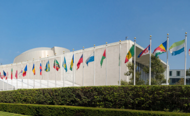 UN United Nations general assembly building with world flags flying in front - September 1, 2015, First avenue, New York City, NY, USA Foto: anaglic/AdopeStock